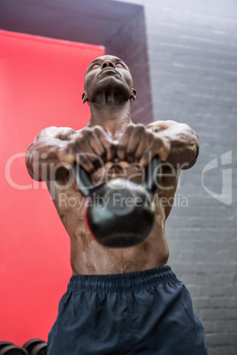 Muscular man lifting a kettlebell