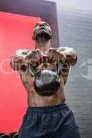 Muscular man lifting a kettlebell