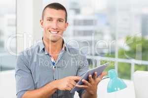 Smiling businessman pointing at his tablet