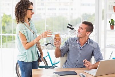 Businesswoman handing a mug of coffee to his colleague