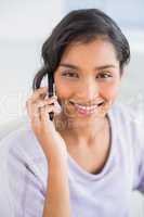 Casual businesswoman talking on phone smiling at camera