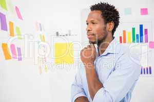 Young serious businessman looking at sticky notes