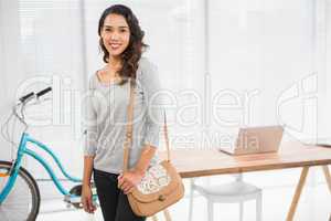 Young businesswoman stands in front of a desk