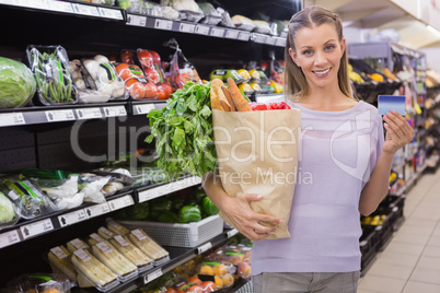 Pretty blonde woman holding bag and credit card