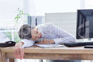 Tired businesswoman sleeping at her desk