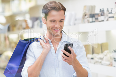 A happy smiling man looking at the phone