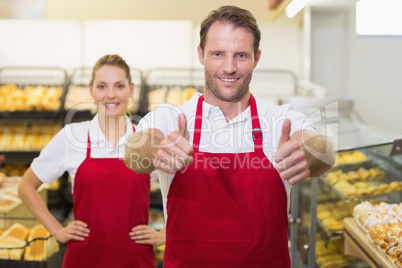 Portrait of smiling two bakers with thumb up