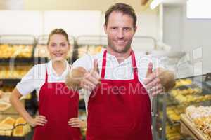 Portrait of smiling two bakers with thumb up