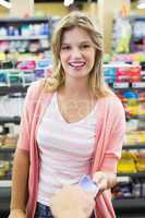 Portrait of a smiling woman paying at cash register paying with