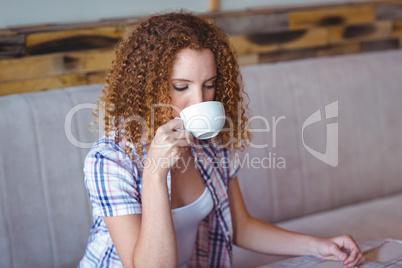 Pretty curly hair girl enjoying a cup of coffee