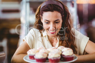 Pretty brunette looking at cakes