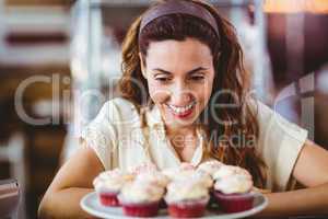 Pretty brunette looking at cakes