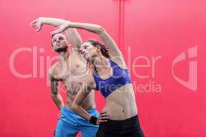 Muscular couple doing arms stretching