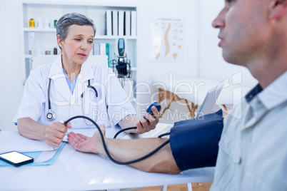 Doctor checking blood pressure of her patient