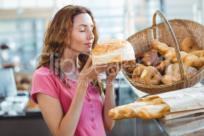 Pretty brunette smelling loaf of bread