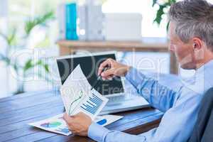 Businessman looking at documents with graphic