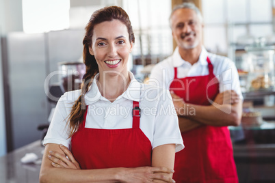 Two baristas smiling at the camera with arms crossed