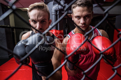 Two boxing men behind the netting