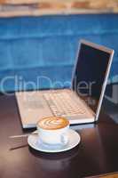 Close-up of laptop and coffee on table