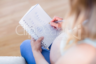 Pregnant woman writing down some notes