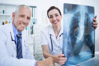 Portrait of smiling medical colleagues holding x-ray