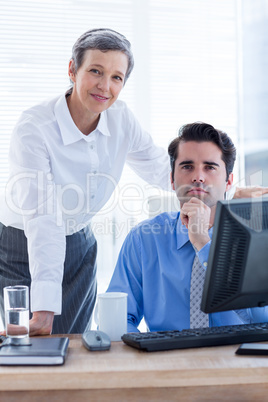 Portrait of two colleagues working together on computer