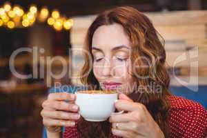 Casual brunette drinking coffee