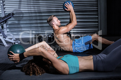 Muscular couple doing abdominal crunch