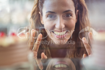 Pretty brunette looking at camera through the glass