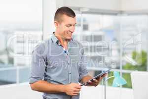 Smiling businessman watching at his tablet