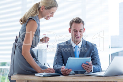 Businessman with secretary looking at tablet