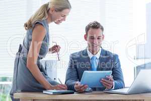 Businessman with secretary looking at tablet