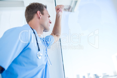 Thoughtful doctor looking through the windows