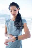 A businesswoman using her smartwatch