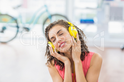 Young creative businesswoman enjoying music