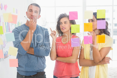 Concentrated coworkers pointing sticky notes