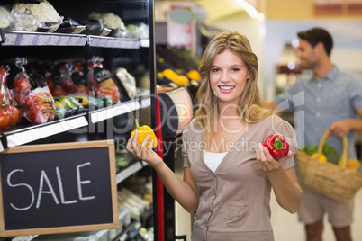 Portrait of a smiling pretty blonde woman buying vegetables