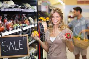 Portrait of a smiling pretty blonde woman buying vegetables