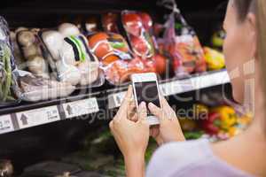 Woman reading her shopping list on smartphone