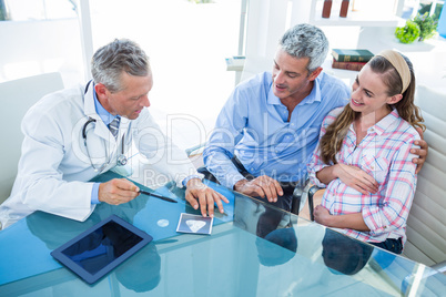 Pregnant woman and her husband discussing with doctor