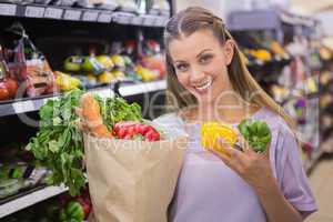 Smiling pretty blonde woman buying vegetables