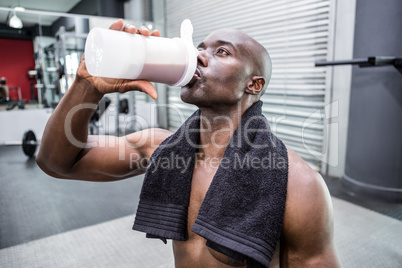 Young Bodybuilder drinking a bottle of water after the training