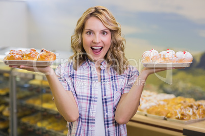 Portrait of a smiling blonde woman having a pastry
