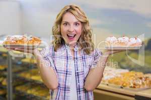 Portrait of a smiling blonde woman having a pastry