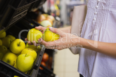 Smiling pretty blonde woman buying apples