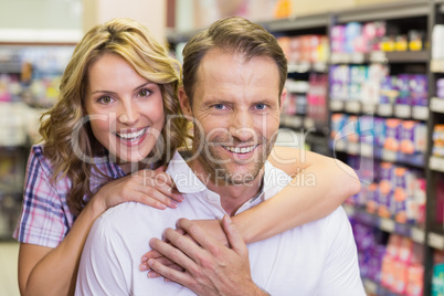 Portrait of smiling casual couple with arm aroung