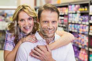 Portrait of smiling casual couple with arm aroung