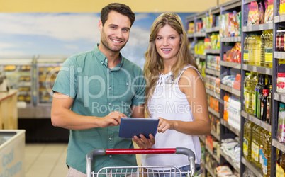 Portrait of bright couple using digital tablet