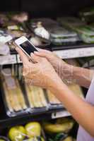 Woman reading her shopping list on smartphone