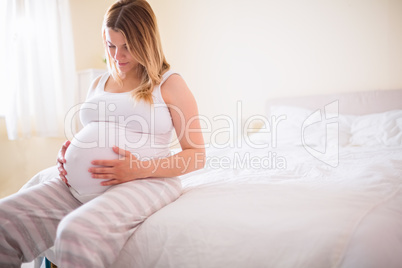 Pregnant woman looking at her belly